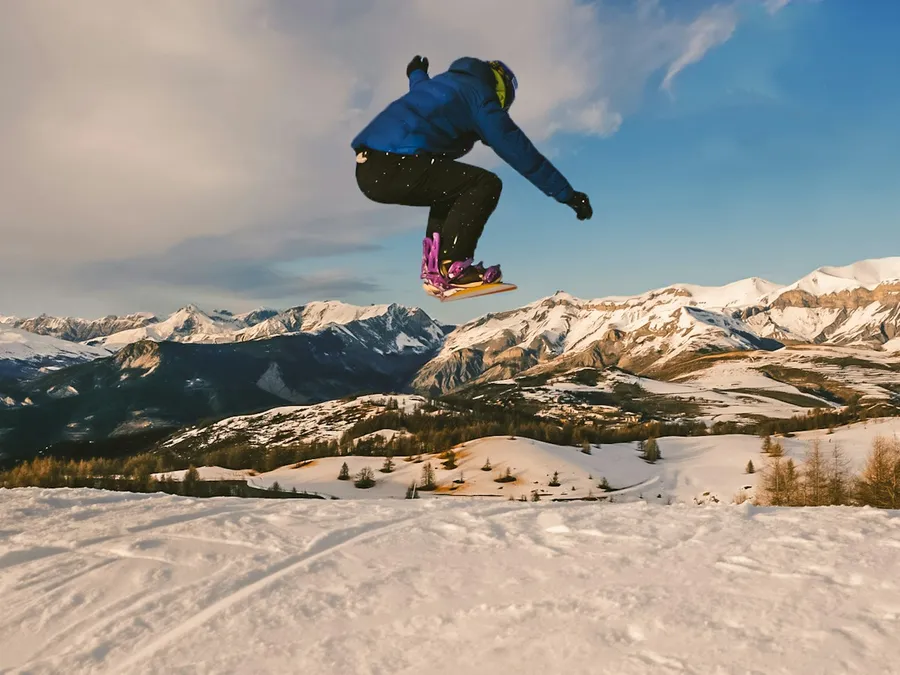 Snowboarder jumping with the Alps behind, Valberg